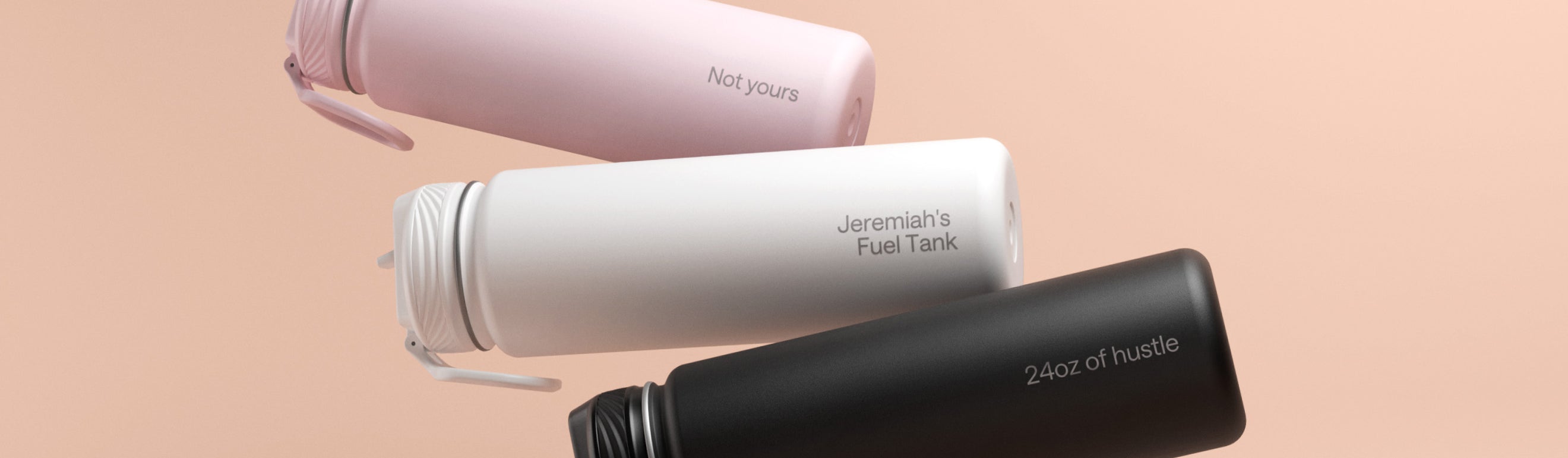 Three custom-engraved bottles in different colors featuring text: '24 oz of hustle,' 'Jeremiah's Fuel Tank,' and 'Sip if you're an NYC finisher,' arranged on a peach background.