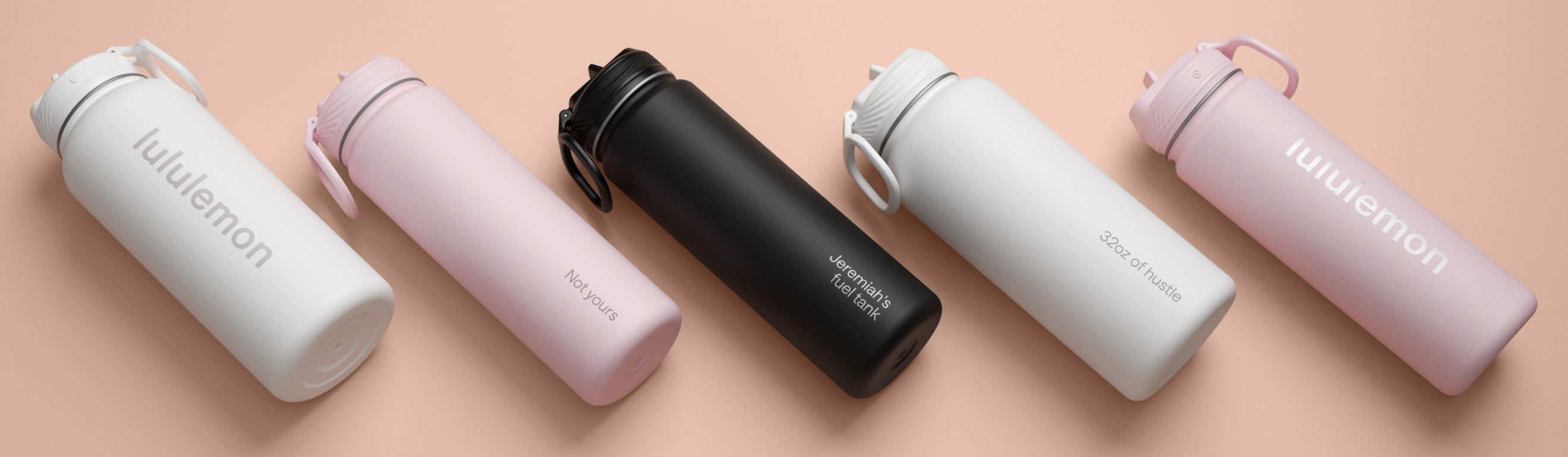 custom-engraved bottles in different colors arranged diagonally on a peach background